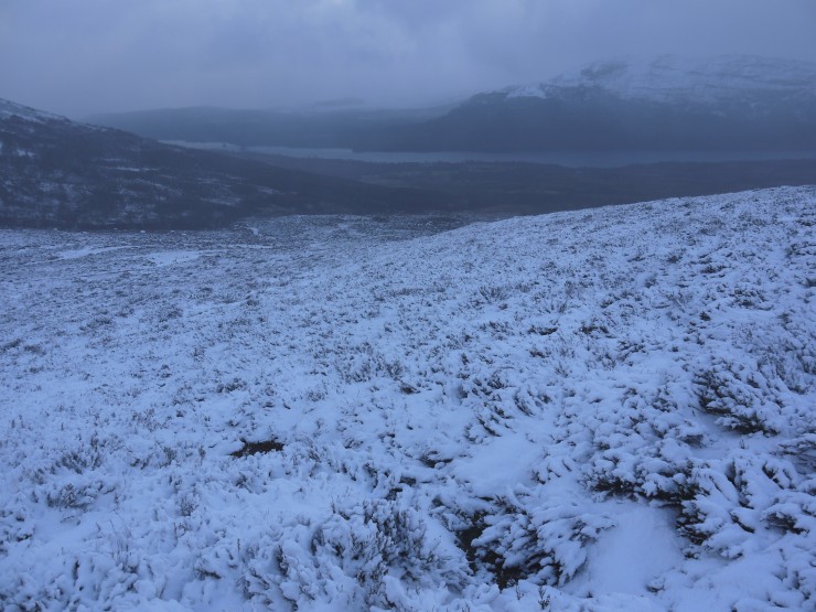 Looking down to a steely grey Loch Laggan during a snow shower.