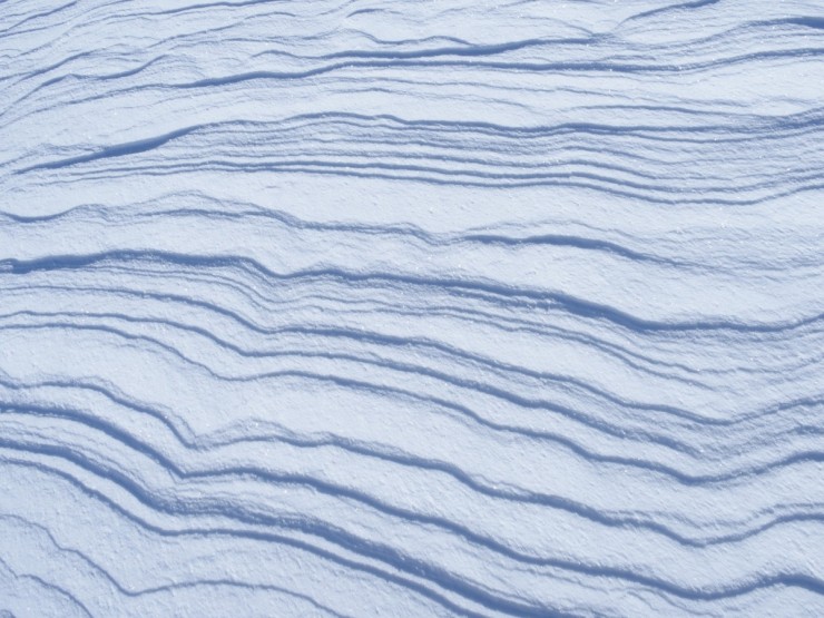 Wind eroded snow. The steeper faces which are in the shade in this photo face into the wind.